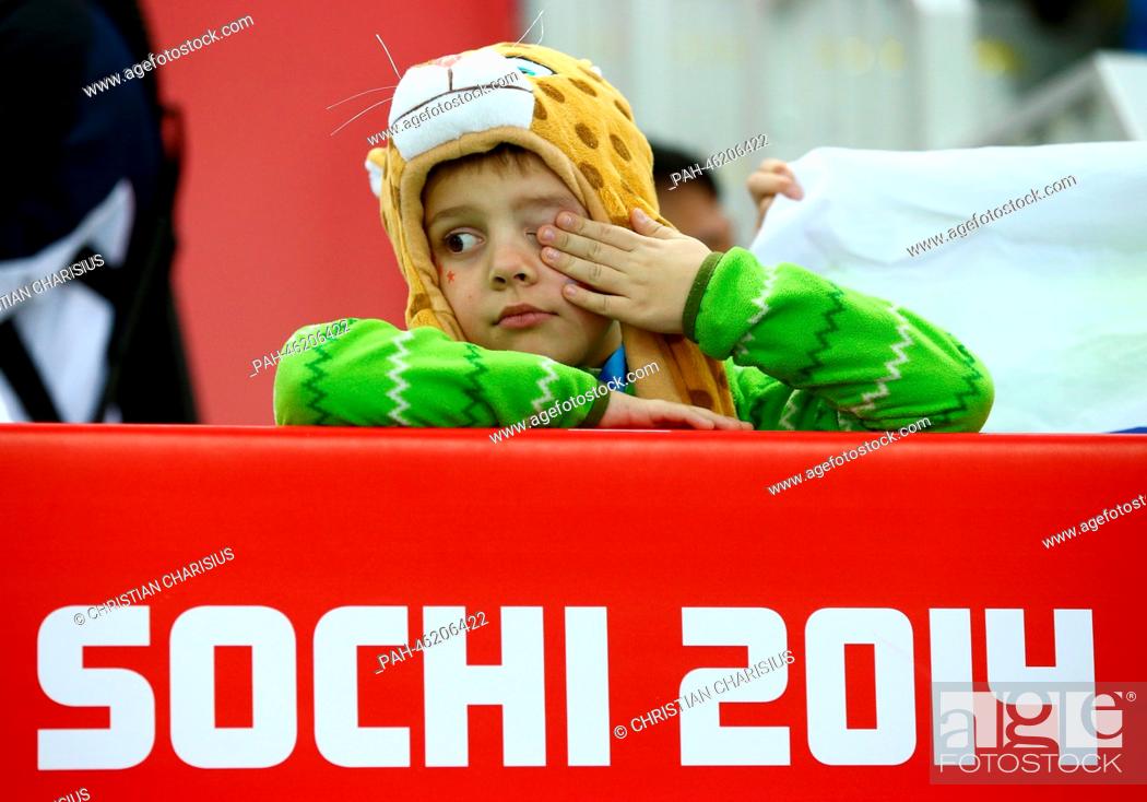 Stock Photo: A young child wipes their eye during Men's 500 m in Adler Arena at the Sochi 2014 Olympic Games, Sochi, Russia, 10 February 2014.