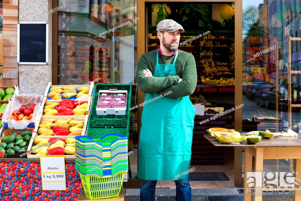 Stock Photo: Grocer with arms crossed in front of greengrocer's shop.