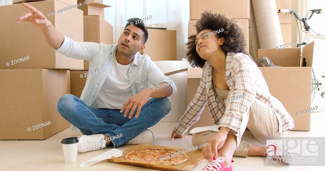Stock Photo: Young couple eating pizza and chatting.