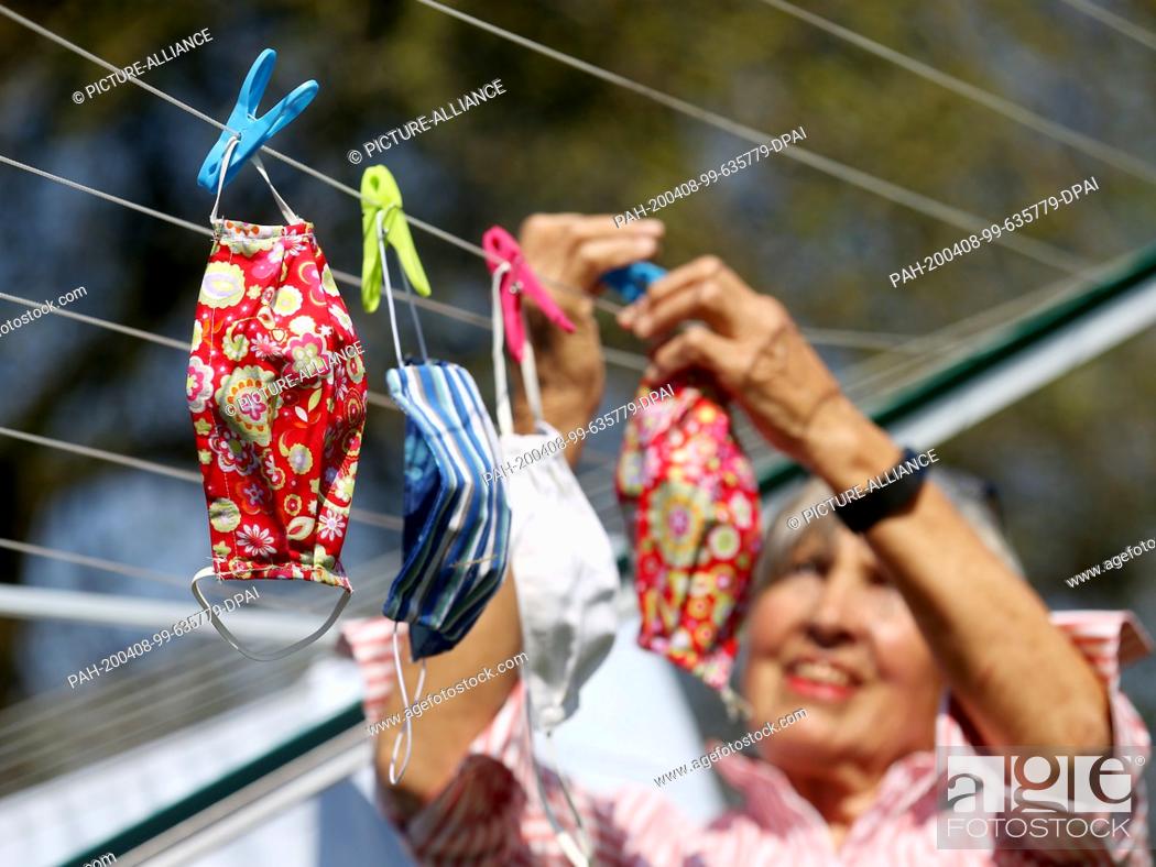 Stock Photo: 08 April 2020, North Rhine-Westphalia, Mülheim: The 79-year-old pensioner Inge Vincents hangs up her self-sewn face masks to dry after washing them at 60.