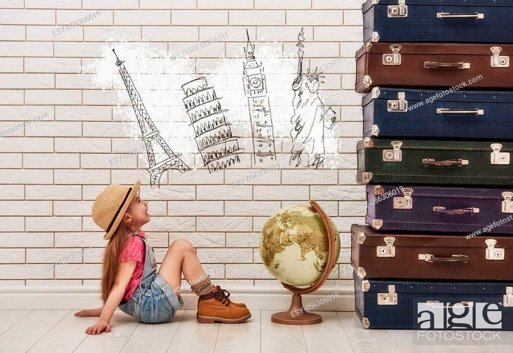 Stock Photo: happy child girl against a white brick wall. girl having suitcases and dreaming of traveling.