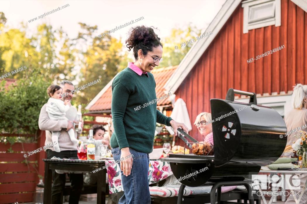 Stock Photo: Smiling woman preparing food on barbecue.