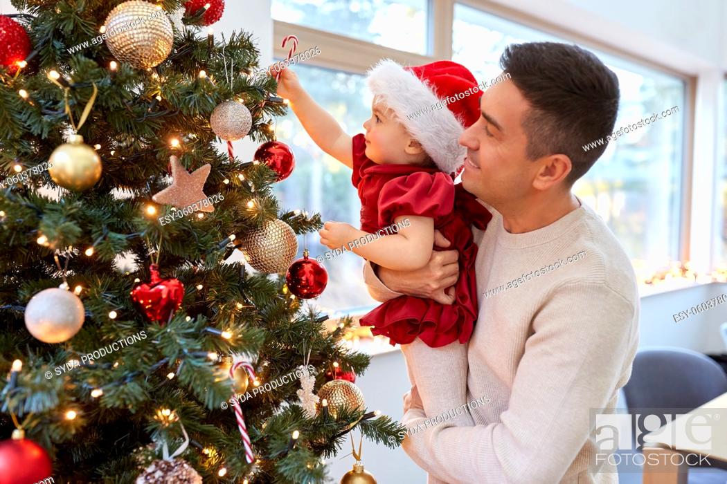 Stock Photo: happy father and baby girl decorate christmas tree.