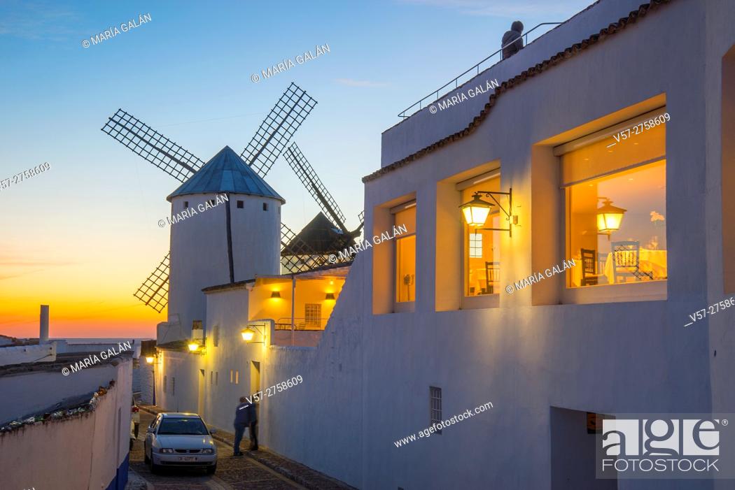 Stock Photo: Street and windmills at sunset. Campo de Criptana, Ciudad Real province, Castilla La Mancha, Spain.