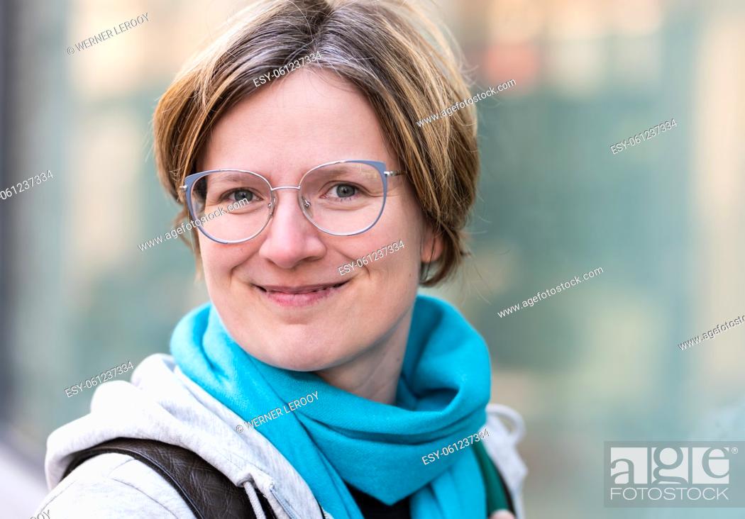 Stock Photo: Mirrored portrait of a 35 year old white woman , standing against a glass window, Brussels, Belgium.