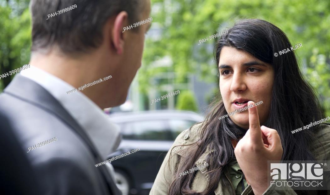 Stock Photo: Spokesperson of the organization 'Anatolian Federation', Sevcan Adiguel (R) talks to media representatives opposite of the Higher Regional Court in Munich.
