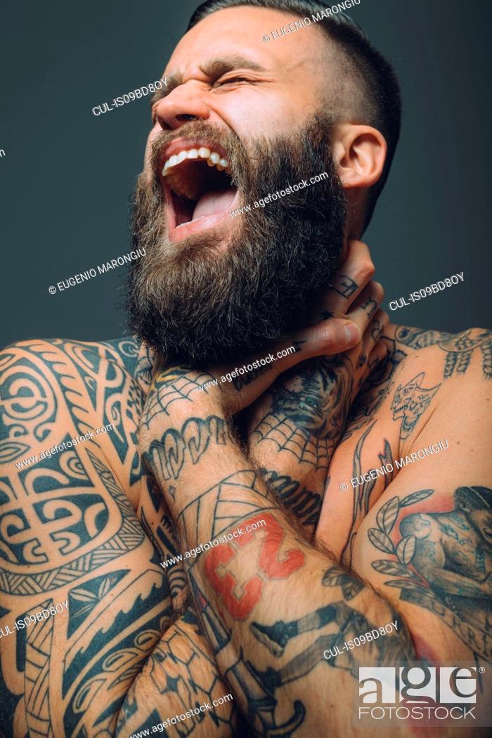 Portrait of young man with beard, covered in tattoos, hands around throat,  screaming, Stock Photo, Picture And Royalty Free Image. Pic. CUL-IS09BD8OY  | agefotostock