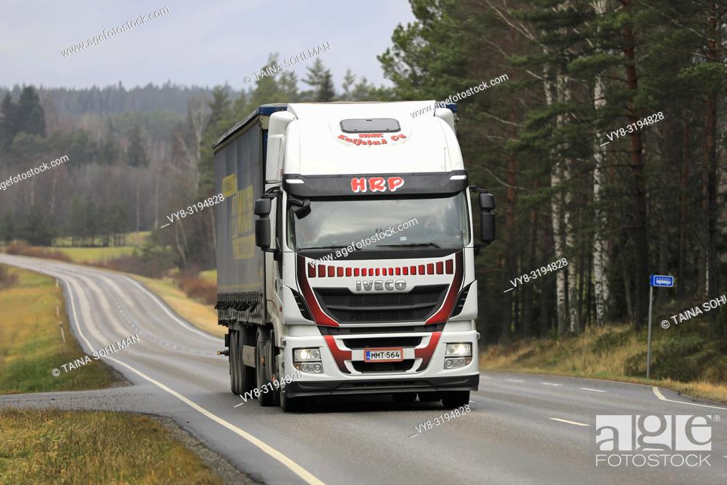 Stock Photo: Salo, Finland - November 16, 2018: Iveco Stralis truck of HMK Kuljetus Oy pulls trailer along rural highway on overcast day of autumn in Finland.