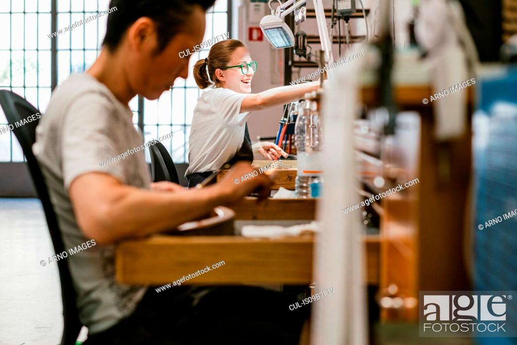 Photo de stock: Male and female jewellers working at workbench.