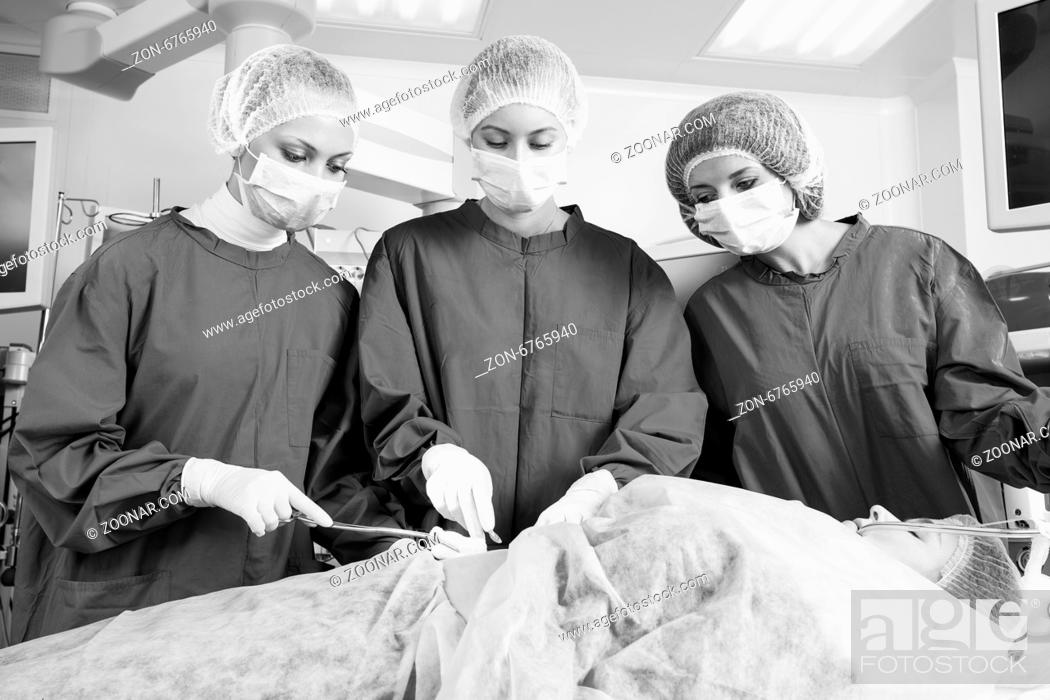 Stock Photo: Surgery team operating in a surgical room.