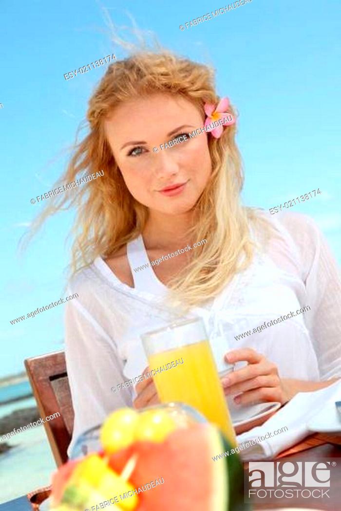 Stock Photo: Beautiful woman having breakfast by the sea.