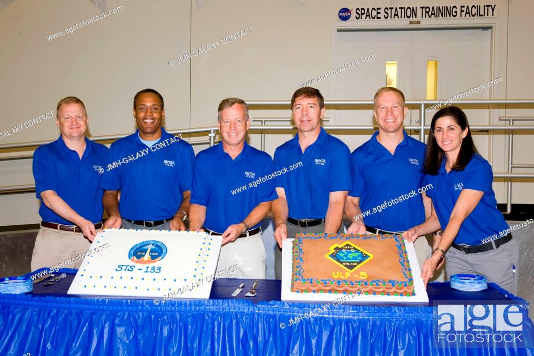 Stock Photo: STS-133 crew members pose for a photo during a cake-cutting ceremony in the Jake Garn Simulation and Training Facility at NASA's Johnson Space Center.