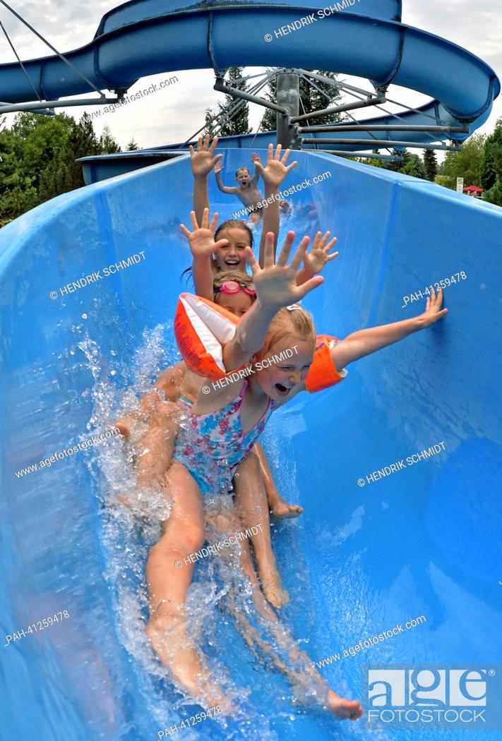 Stock Photo: Children slide down the 75 m long waterslide in the bath of Rebesgruen, Germany, 24 July 2013. This weekend the 17th German water sliding championship will take.