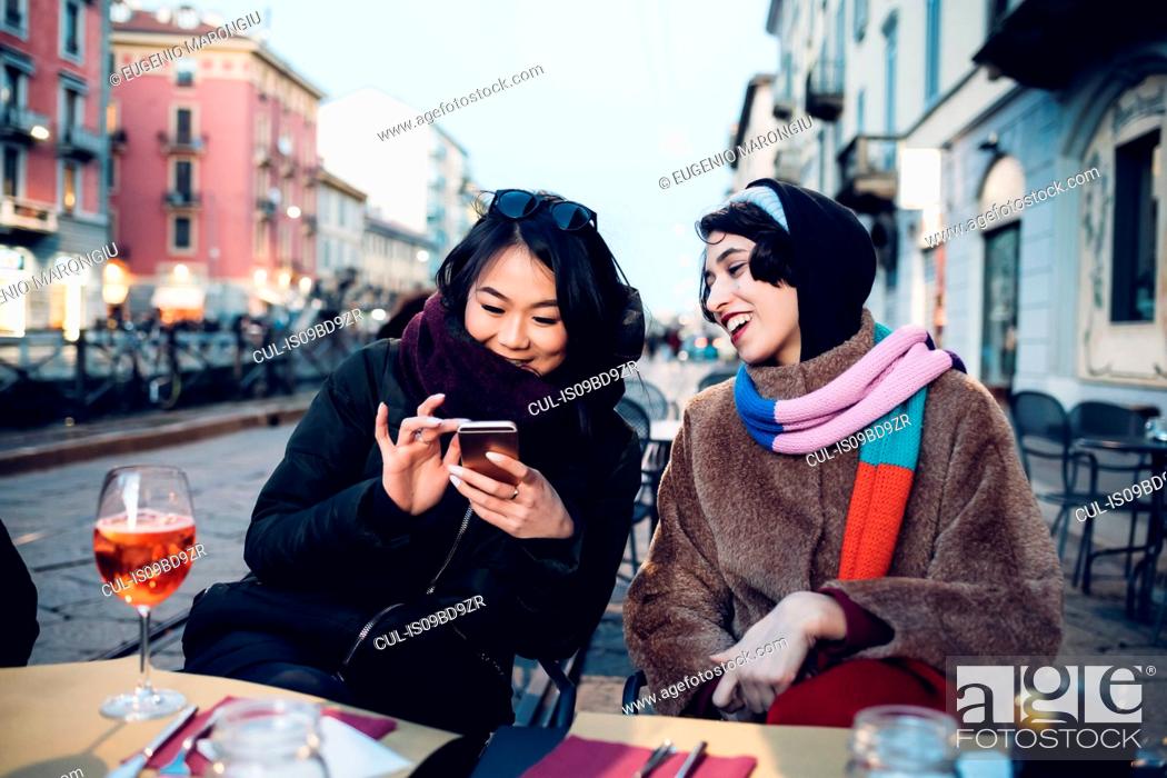 Stock Photo: Friends enjoying drink at outdoor cafe, Milan, Italy.