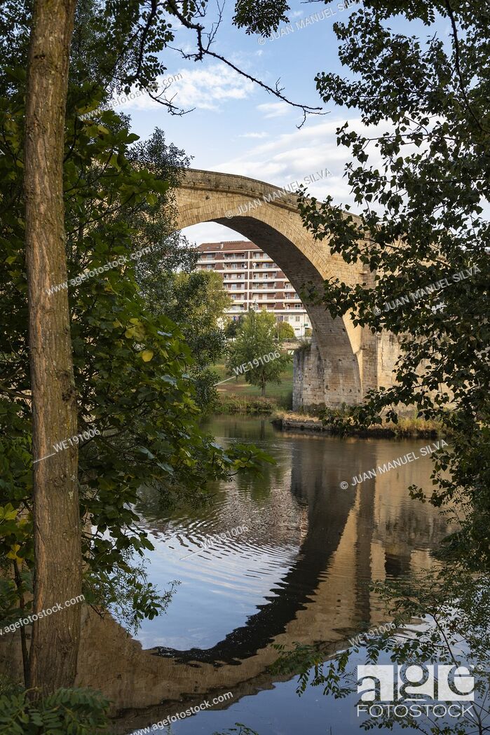 Stock Photo: Roman bridge in Ourense (Galicia, Spain), over river Miño and city scape in the background.