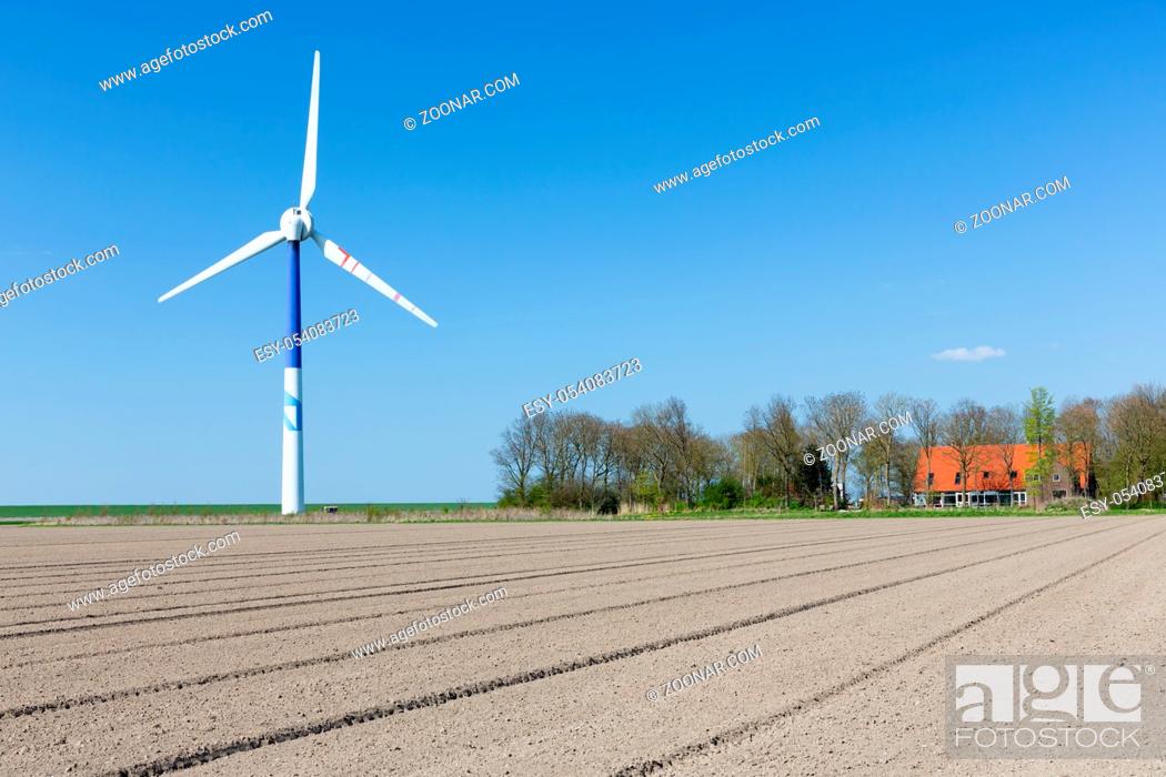 Stock Photo: Big wind turbine in Dutch Farmland with farmhouse.