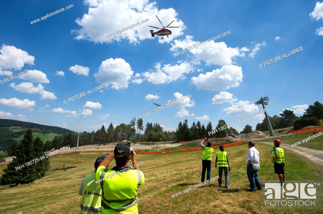 Stock Photo: 25 July 2018, Willingen, Germany: The last parts of a chairlift support of the new 8-seater chairlift ""K1 Willingen"" on the Köhlerhagen runway are transported.
