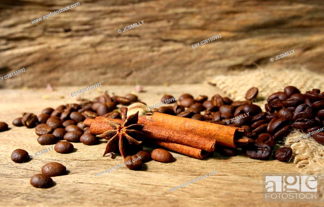 Stock Photo: Roasted coffee beans and spices on grunge wooden board background.