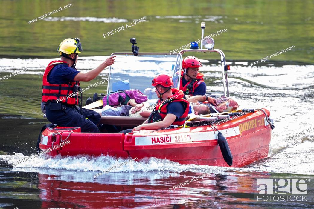 Stock Photo: 24 August 2019, Saxony, Bad Schandau: Injured persons are taken away by boat by rescue forces during the ""Schöna 2019"" national disaster control exercise.