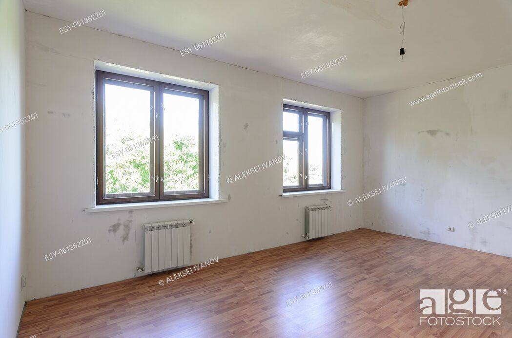 Photo de stock: The interior of an empty room during renovation, there are two large windows in the room, radiators under them.