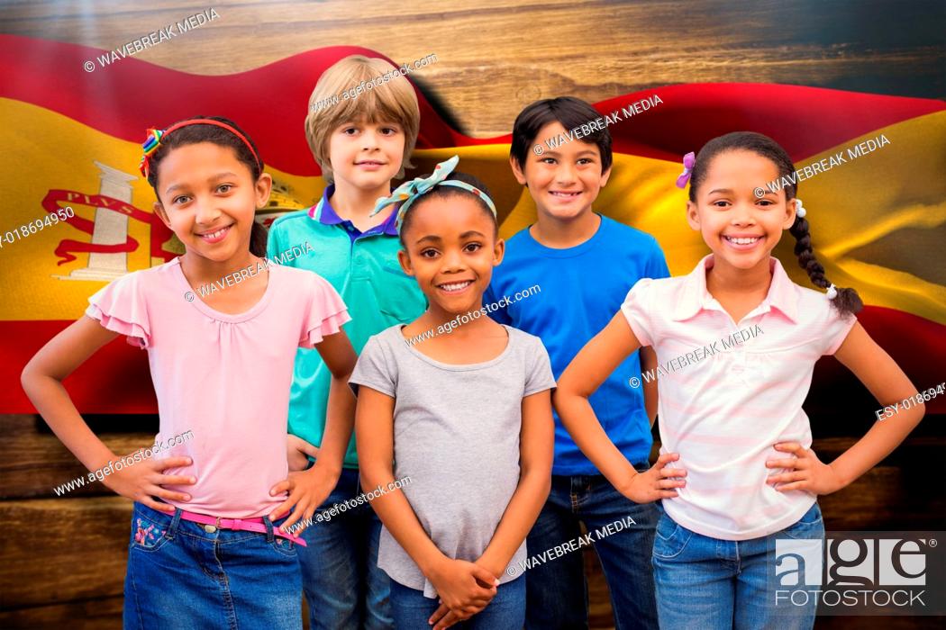 Stock Photo: Composite image of cute pupils smiling at camera in classroom.