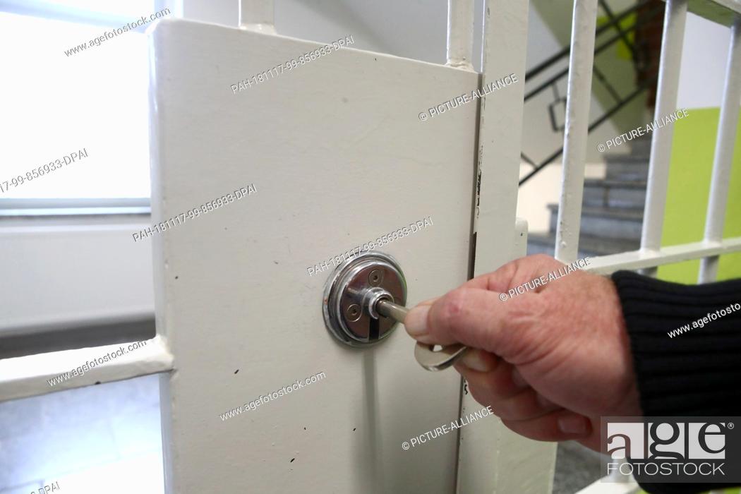 Stock Photo: 13 November 2018, Thuringia, Hohenleuben: A prison officer puts a key into a lock in the Hohenleuben correctional facility.