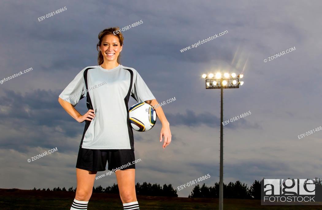 Stock Photo: Female soccer player working out on a soccer field.