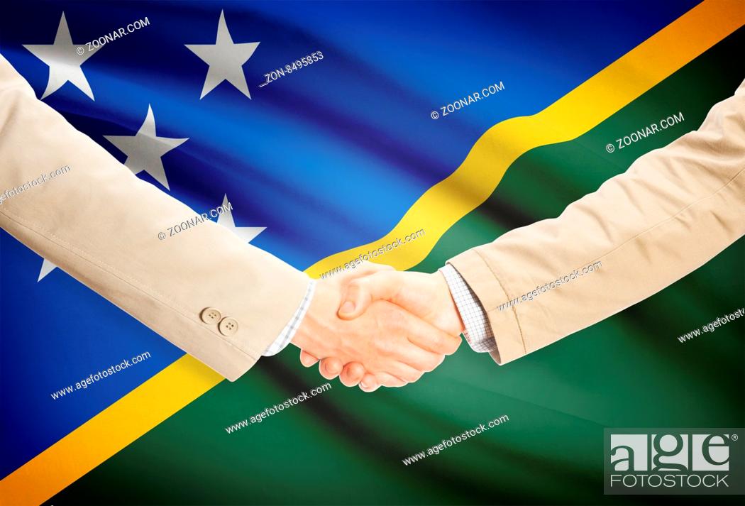 Stock Photo: Businessmen shaking hands with flag on background - Solomon Islands.