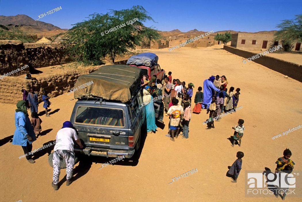 Stock Photo: children forming a crowd around a touristic vehicule having broken down, Aouderas village of Aïr, Niger, Western Africa.