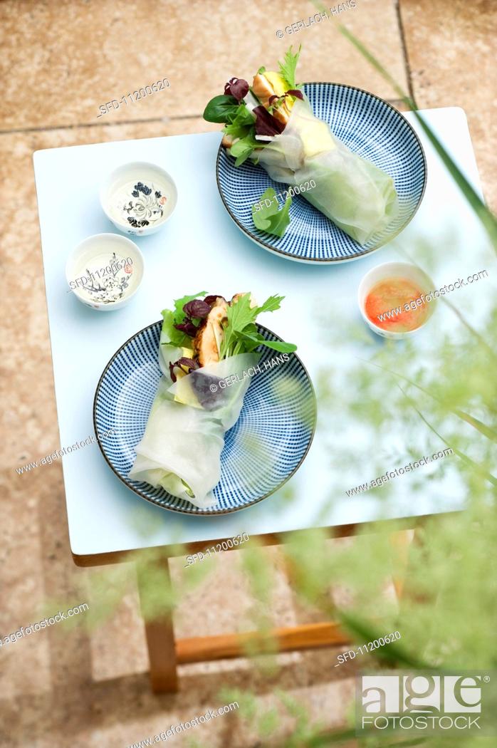 Stock Photo: Spring rolls with chicken on a table on the terrace.
