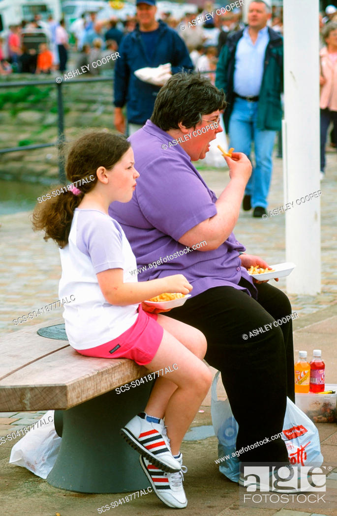 Stock Photo: A fat women and daughter easting chips.