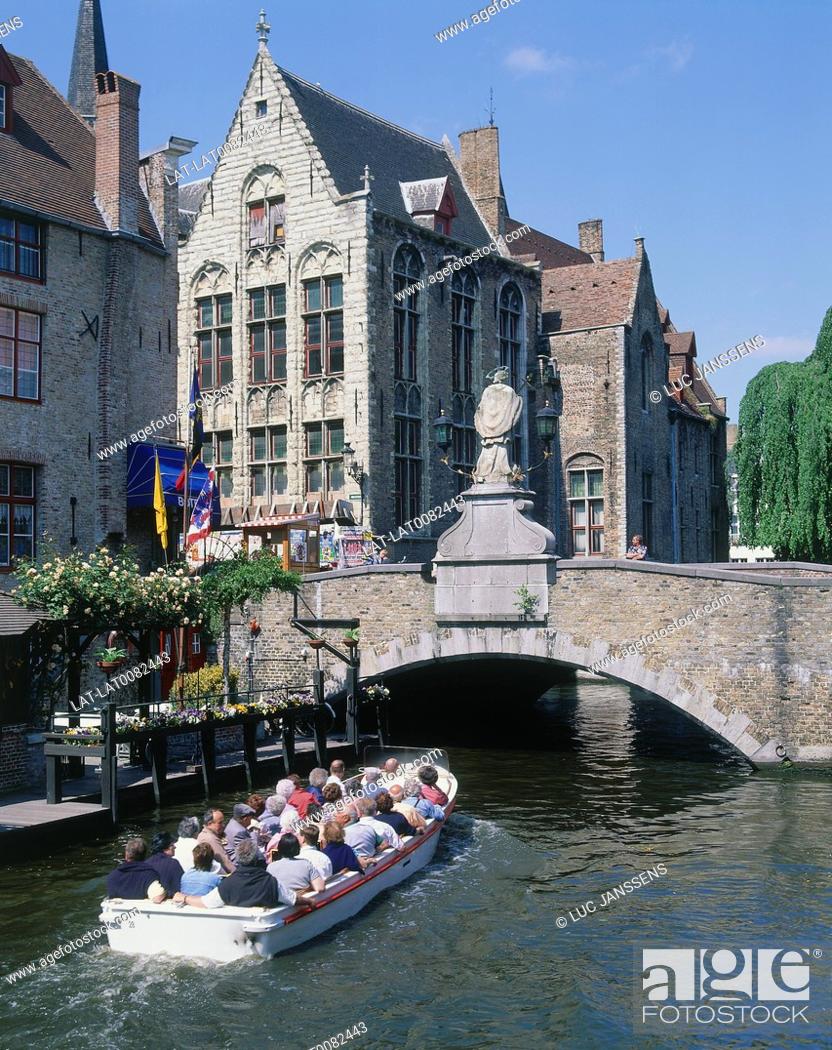 Stock Photo: Dijver. Boat full of people on canal. Bridge with statue of St John Nepomuk. Old stone buildings.