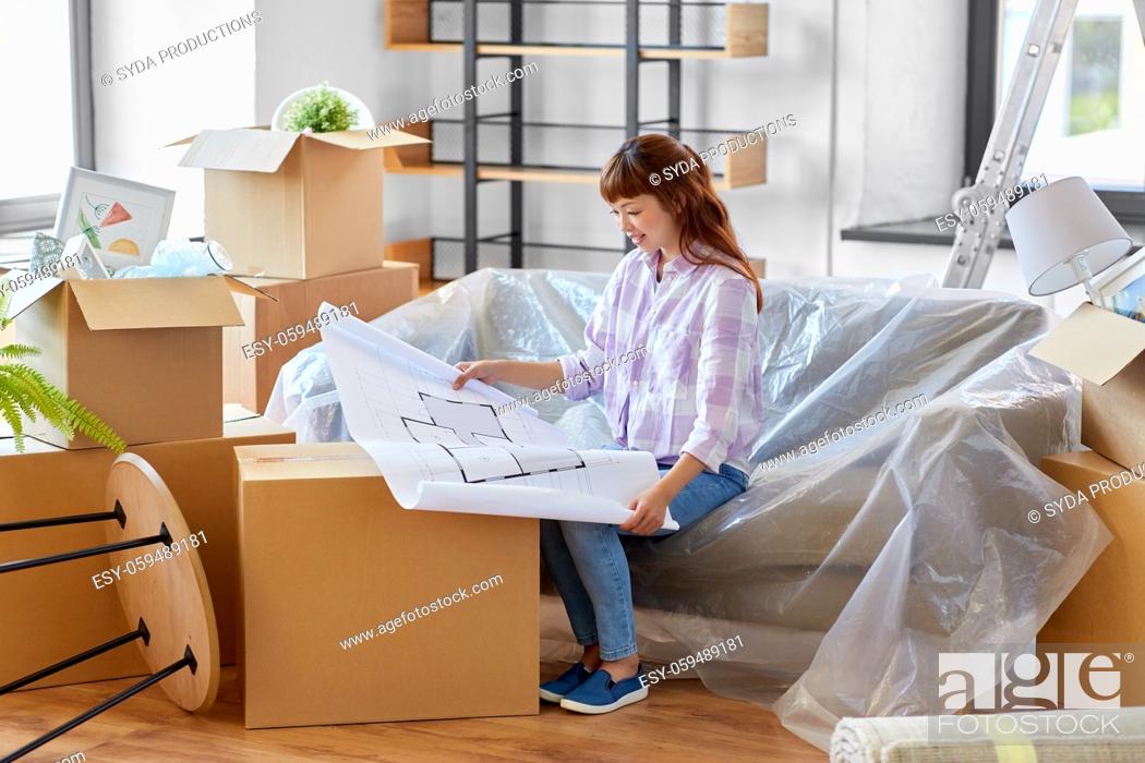 Stock Photo: woman with blueprint and boxes moving to new home.