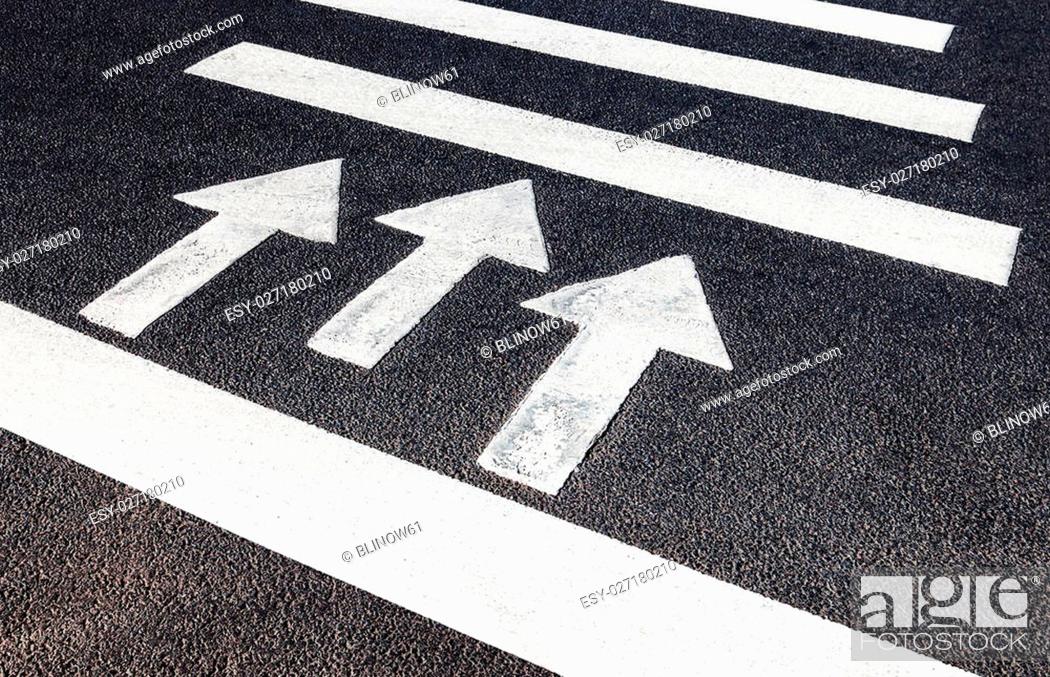 Stock Photo: Urban pedestrian crosswalk with white marking lines and direction of motion on asphalt.