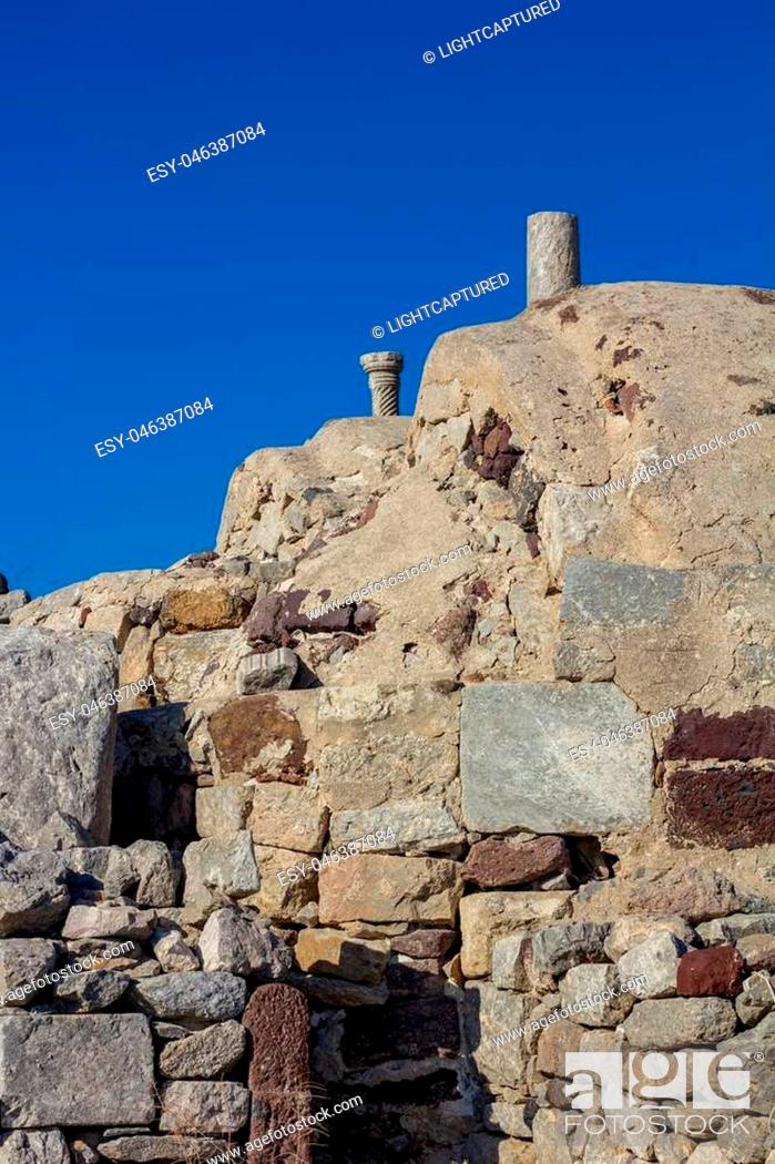 Stock Photo: Typical old stone masonry view scene on Santorini. Fira, Greece, from below. Image taken from public path walk in the morning with clear blue sky as a contrast.