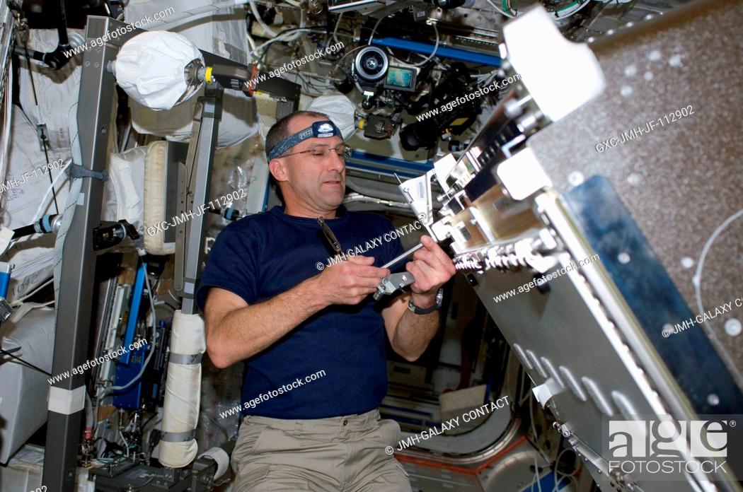Stock Photo: Astronaut Donald Pettit, STS-126 mission specialist, installs the Combustion Integrated Rack (CIR) in the Destiny laboratory of the International Space Station.