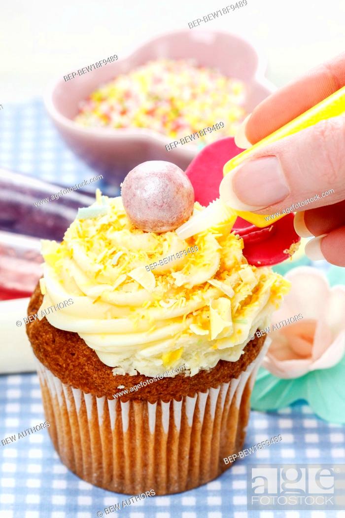 Stock Photo: Woman decorating muffins. Party dessert.