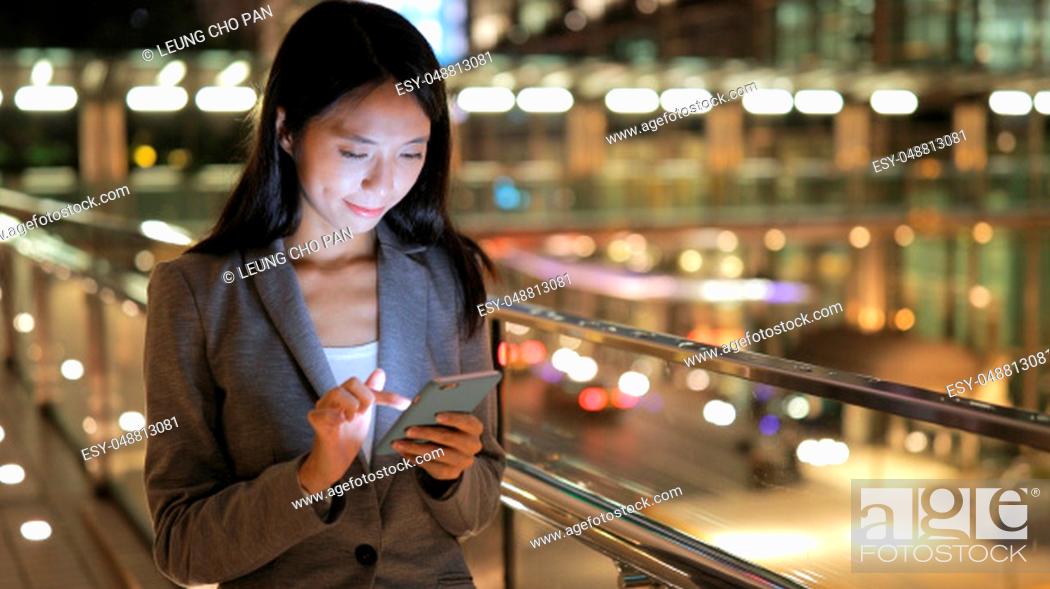Stock Photo: Business woman using smart phone in city.