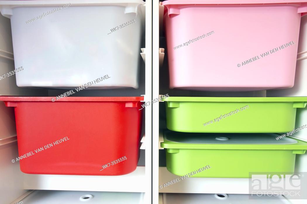 Stock Photo: Stack of plastic storage boxes in different colors, sorting system arrangement close-up.