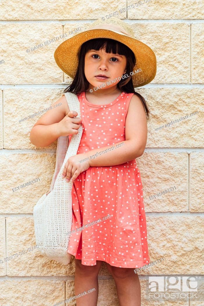 Stock Photo: Portrait of a black-haired girl girl with summer dress, hat and bag.