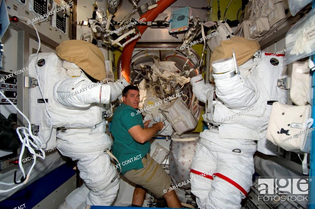 Stock Photo: Astronaut Steve Bowen, STS-126 mission specialist, works in the Quest Airlock of the International Space Station while Space Shuttle Endeavour is docked with.