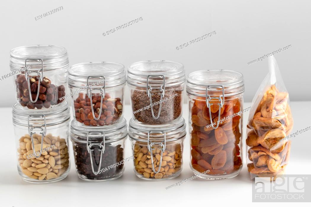 Stock Photo: jars with dried fruits, cereals and nuts on table.
