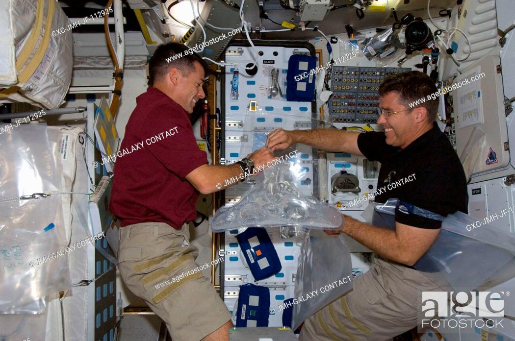 Stock Photo: Astronauts Shane Kimbrough (left) and Steve Bowen, both STS-126 mission specialists, work on the middeck of Space Shuttle Endeavour during flight day three.