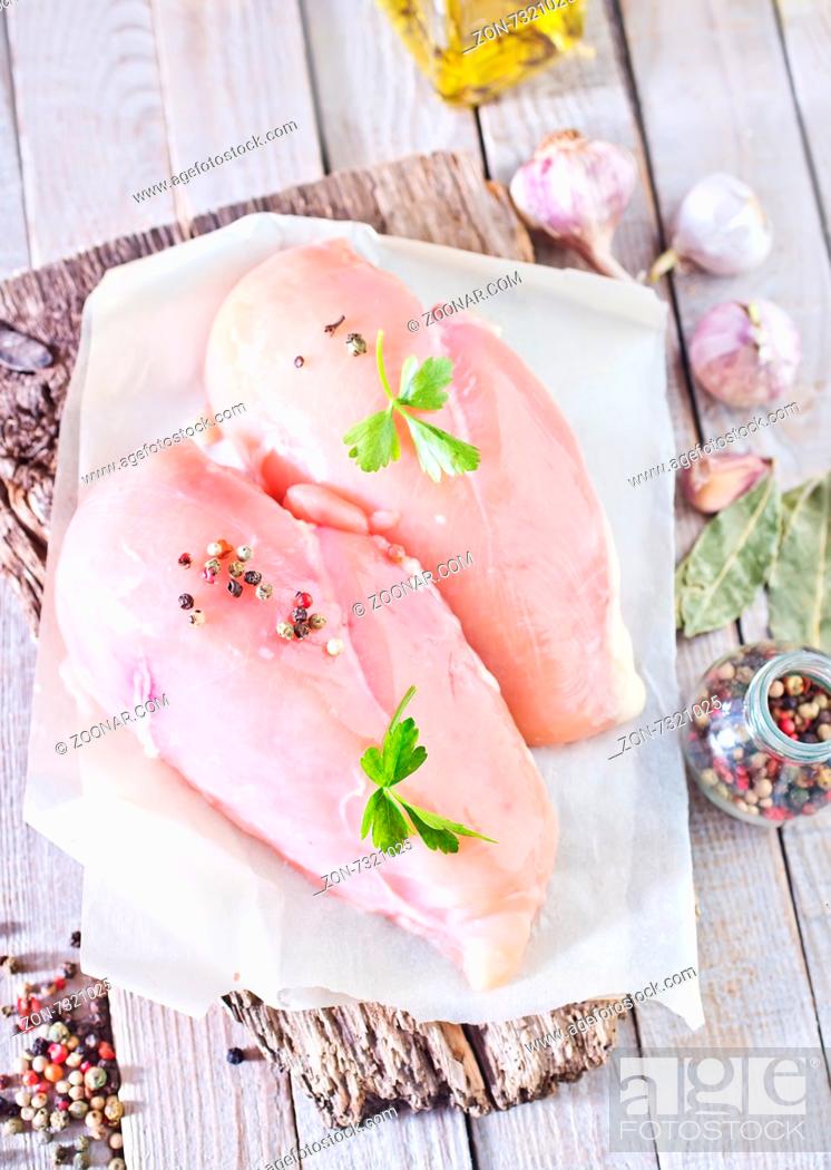 Imagen: raw chicken fillet on board and on a table.