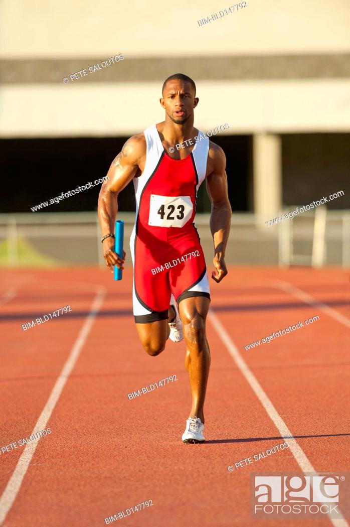 Stock Photo: Black runner running on track in relay race.