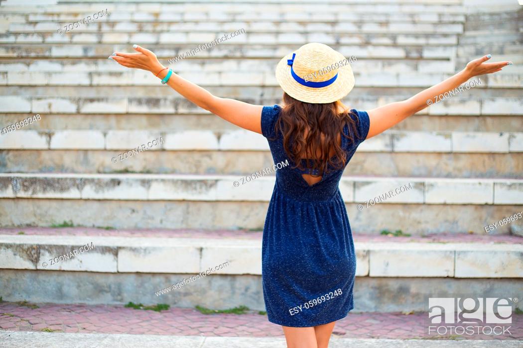 Stock Photo: Beautiful girl on the steps in a blue dress and hat.