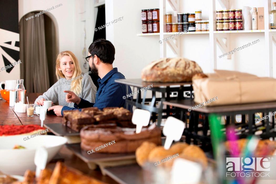 Stock Photo: Customer couple sitting at cafe table chatting.
