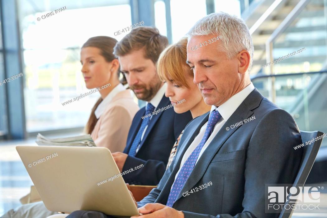 Imagen: Businessman working using laptop in airport departure area.