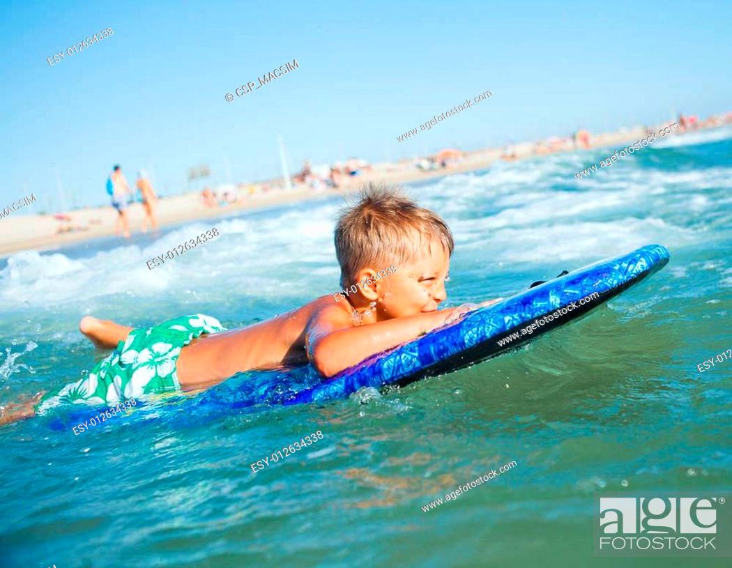 Photo de stock: boy has fun with the surfboard.