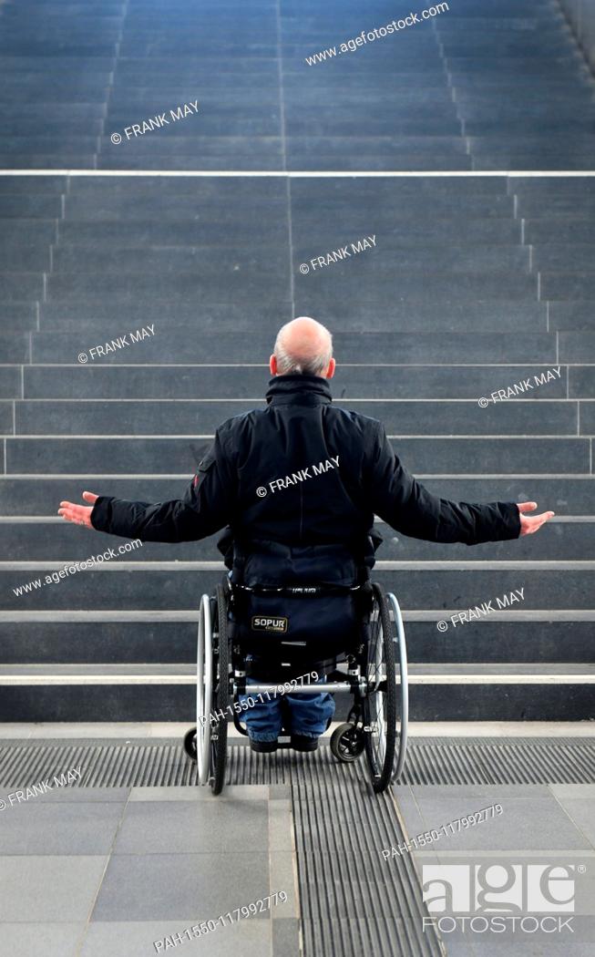 Stock Photo: Illustration: a wheelchair user standing in front of stairs, Germany, city of Hamburg, 05. March 2019. Photo: Frank May (model released) | usage worldwide.